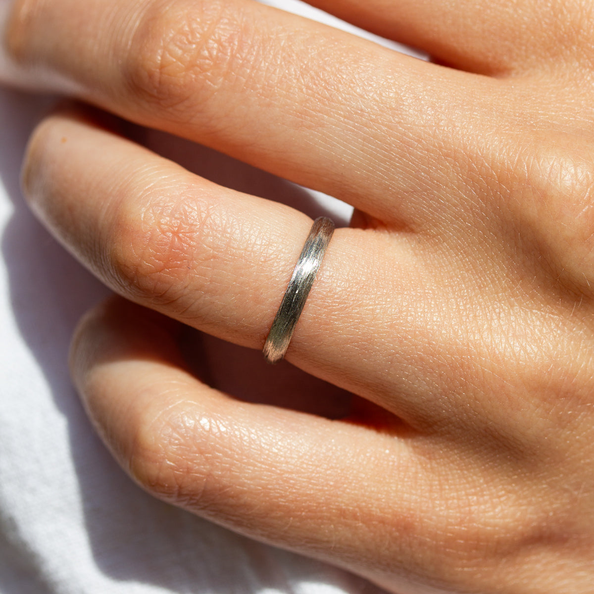 Alliance en or 750/1000 certifié Fairmined, au fini brossé, façonnée dans une joaillerie éthique parisienne.