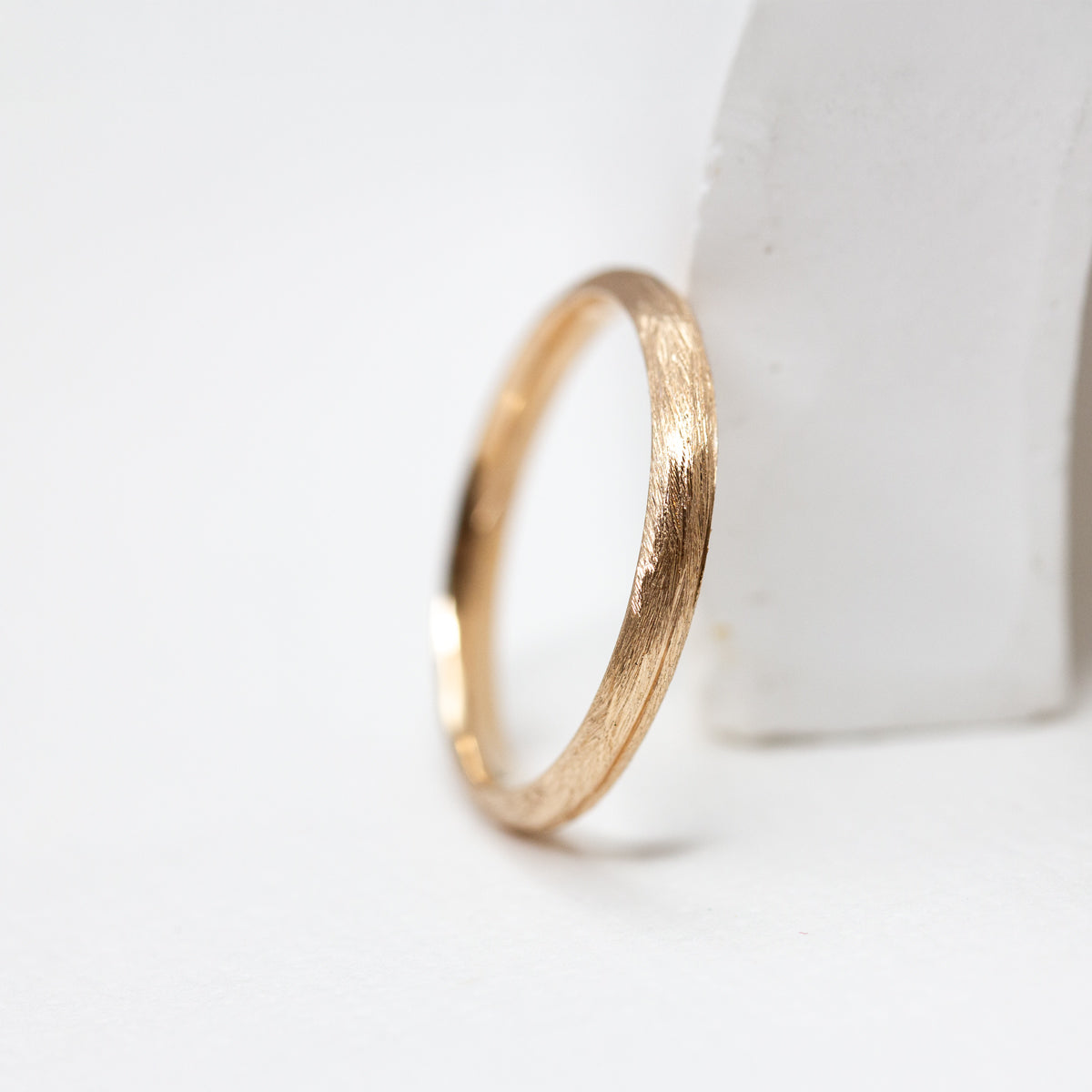 Alliance en or jaune au fini brossé, née des mains d’artisans dans une joaillerie éthique au cœur de Paris.