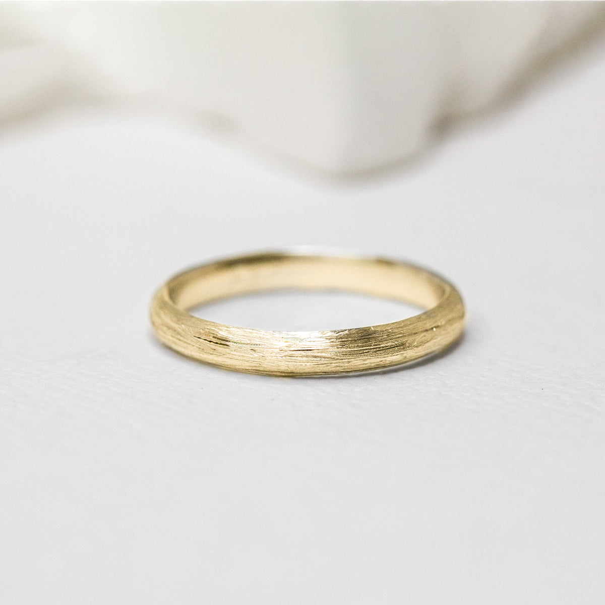 Alliance en or jaune au fini brossé, née des mains d’artisans dans une joaillerie éthique au cœur de Paris.