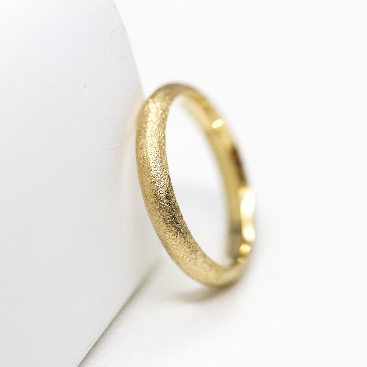 Alliance bombée femme à la texture givrée Gina en or jaune éthique 18 carats Fairmined, réalisée à Paris dans notre atelier artisanal.