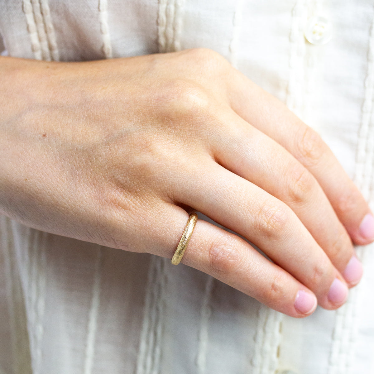 Alliance bombée femme à la texture givrée Gina en or jaune éthique 18 carats Fairmined, réalisée à Paris dans notre atelier artisanal.