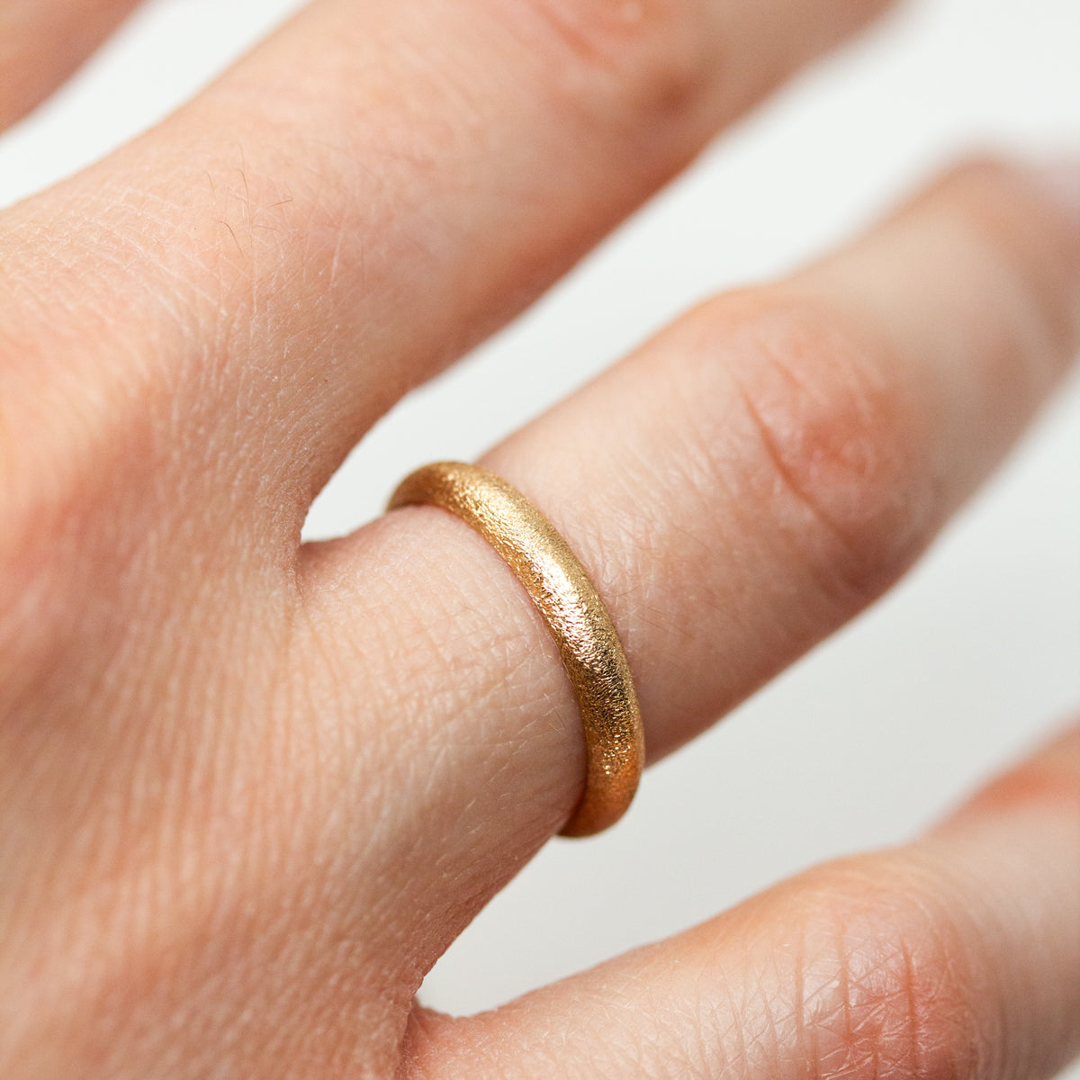 Alliance bombée femme à la texture givrée Gina en or jaune éthique 18 carats Fairmined, réalisée à Paris dans notre atelier artisanal.