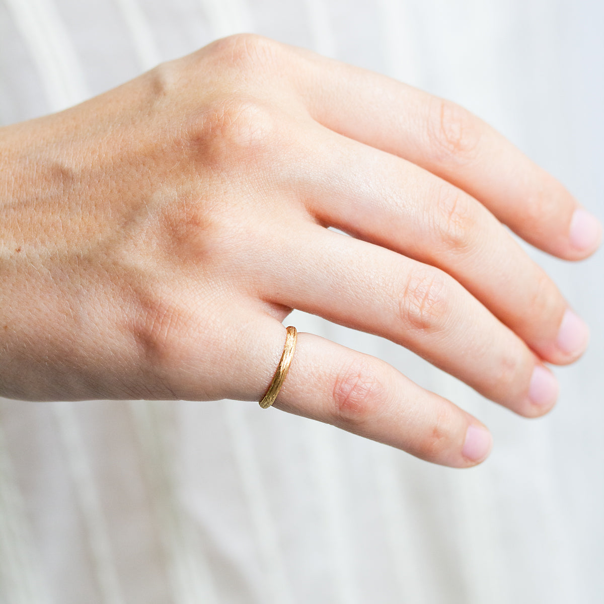 Alliance Casildée fine pour femme texturée en or rouge 18 carats Fairmined, finition brossée, façonnée artisanalement dans notre atelier à Paris.