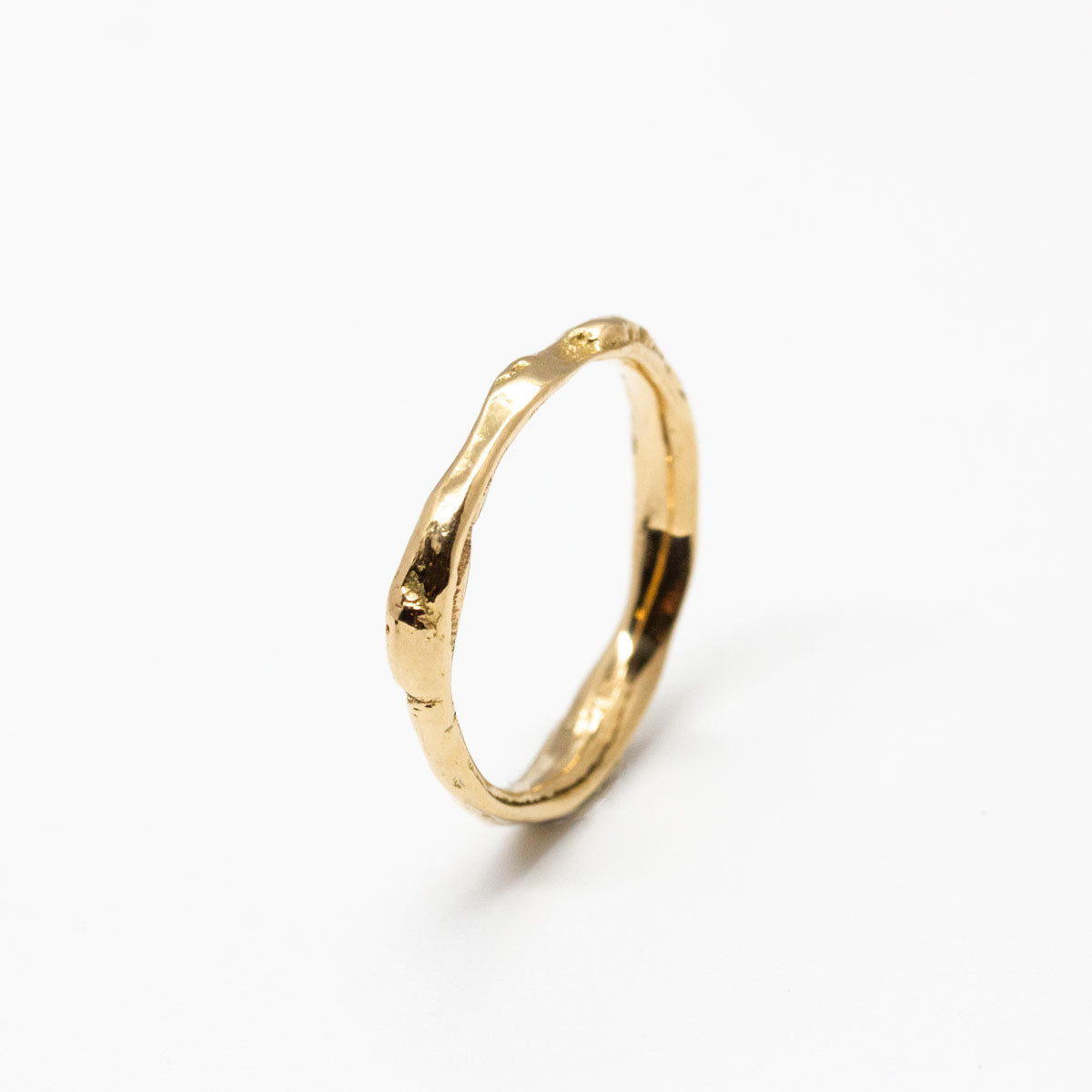 Alliance bague de mariage ondulée mixte en or jaune 750/1000 recyclé + prime Fairmined, avec une texture brute et unique qui rappelle l’or fondu, fabriquée à la main à Paris dans une joaillerie éthique.