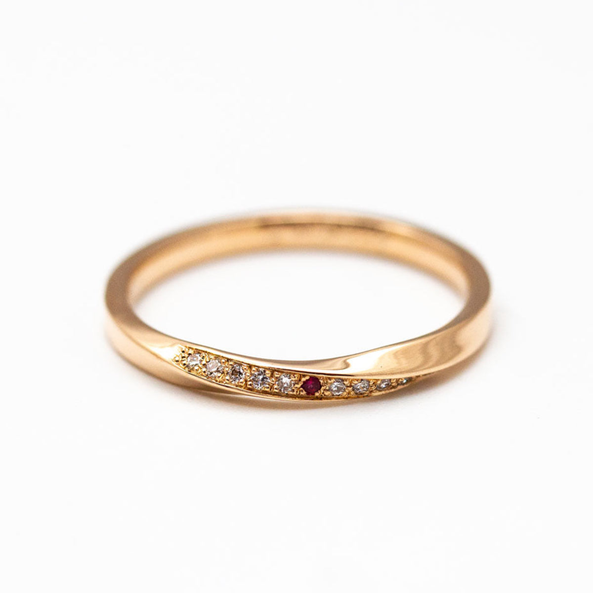 Alliance torsadée en or 750/1000 avec pavage de diamants et rubis, créée sur-mesure dans notre atelier de joaillerie artisanale et éthique