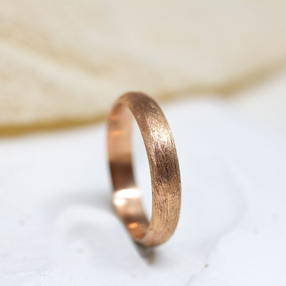 Alliance large de mariage en or rouge.