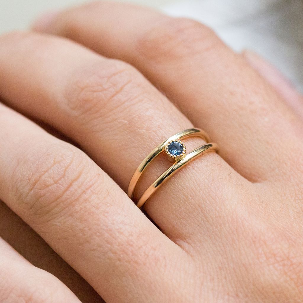 Bague originale double anneaux ornée d'un saphir bleu.