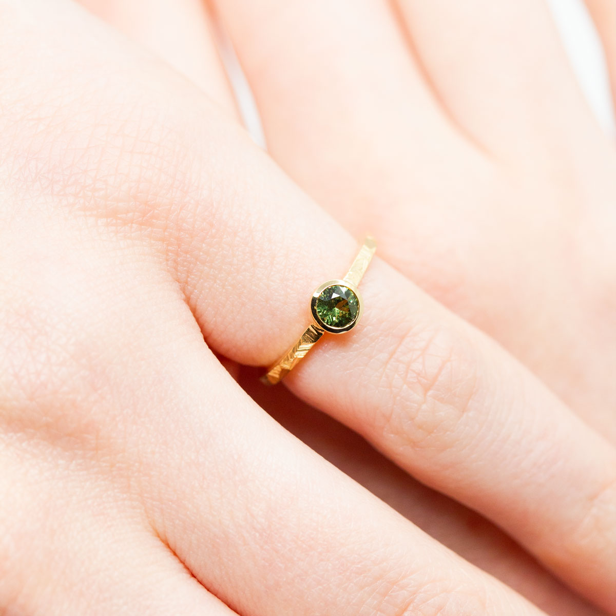 Bague de fiançailles originale femme, solitaire orné d'un saphir vert-jaune en or jaune éthique Fairmined réalisée à la main à Paris dans notre propre atelier de joaillerie responsable
