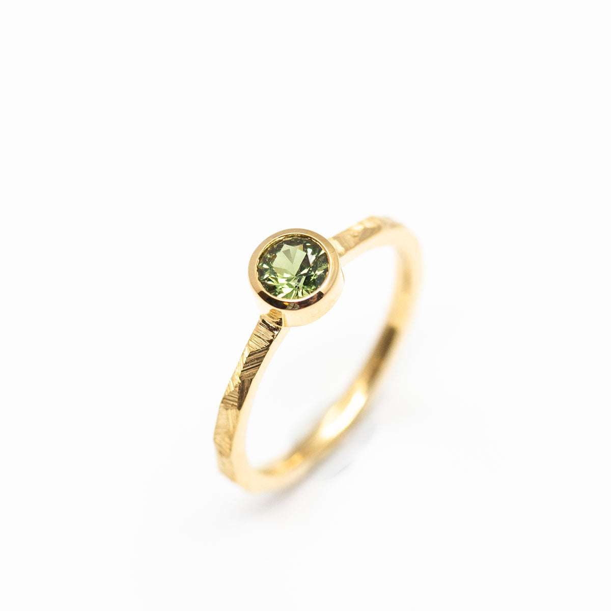 Bague de fiançailles originale femme, solitaire orné d'un saphir vert-jaune en or jaune éthique Fairmined réalisée artisanalement à Paris dans notre propre atelier de joaillerie responsable