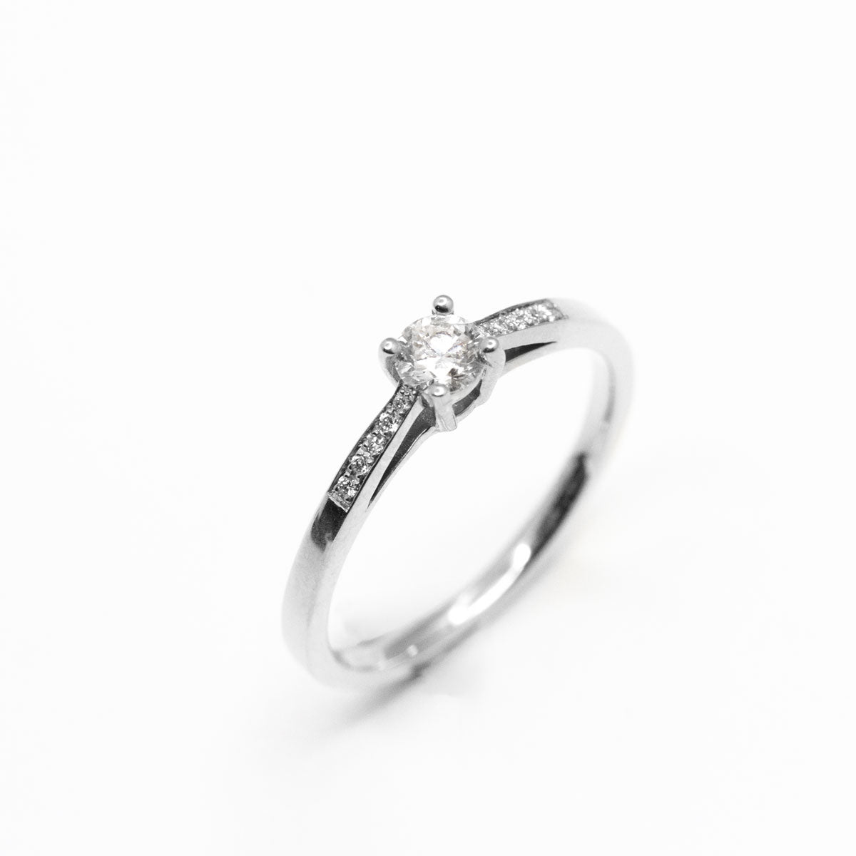 Bague de fiançailles pavée femme sertie d'un diamant central de 5mm et 10 diamants de synthèse en or blanc recyclé 750/1000 + prime Fairmined. Fabriquée avec savoir-faire à la main dans notre atelier de joaillerie à Paris