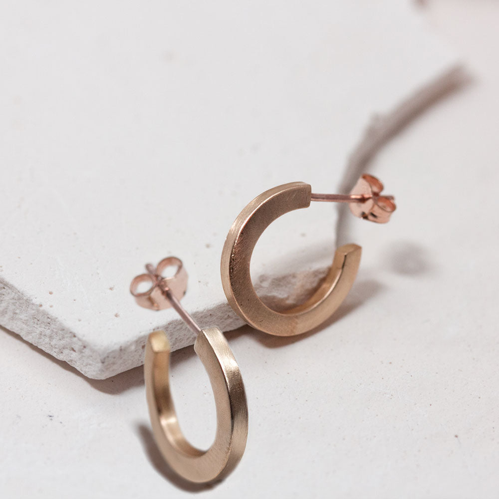 Boucles d'oreille en or rouge éthique 18 carats dans un atelier artisanal à Paris.