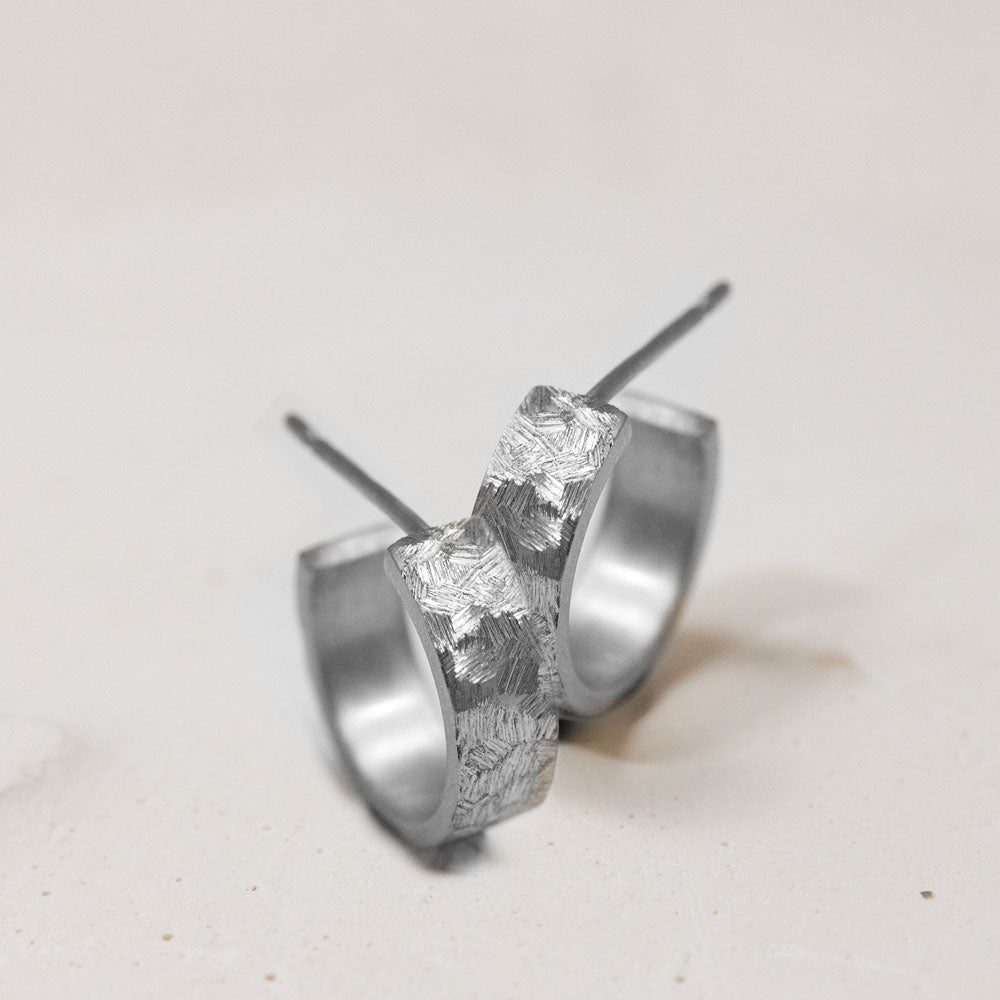 Boucles d'oreille en or blanc réalisées dans un atelier de joaillerie artisanale.