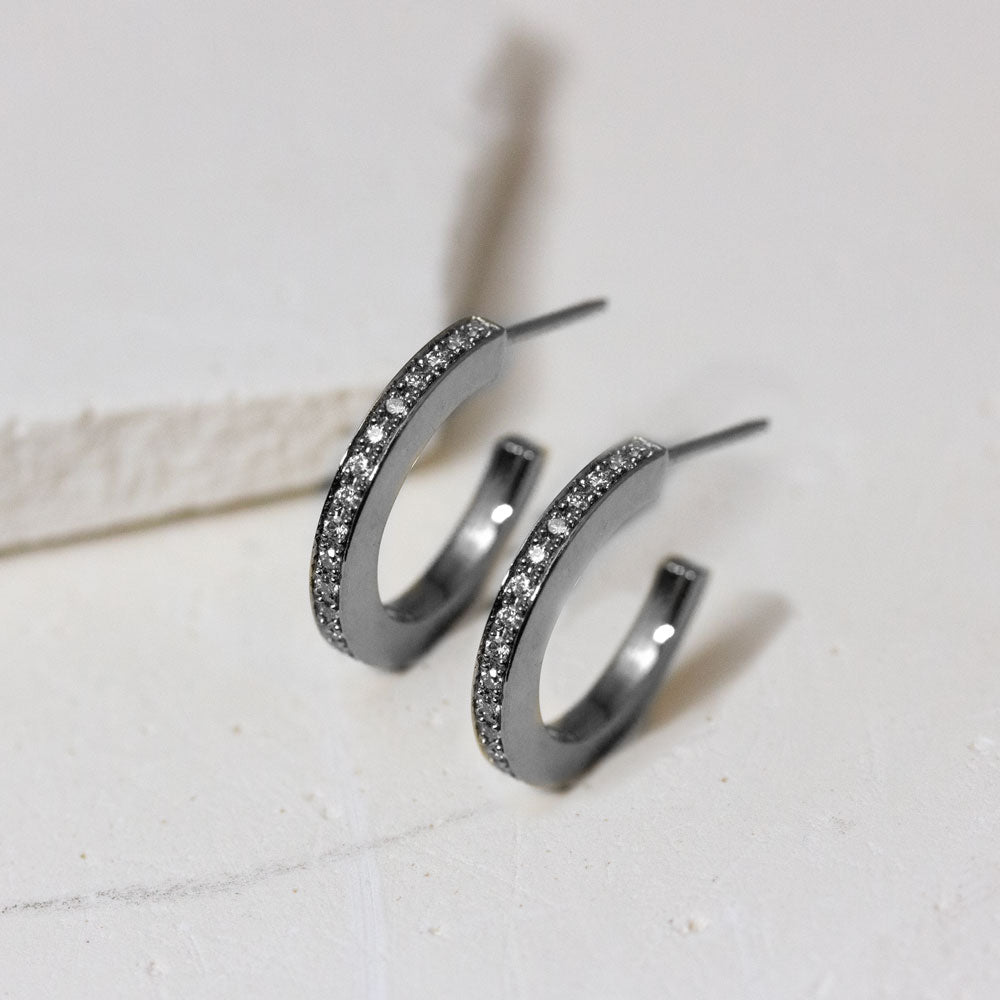 Boucles d'oreille en or gris palladié réalisées dans un atelier de joaillerie à Paris.