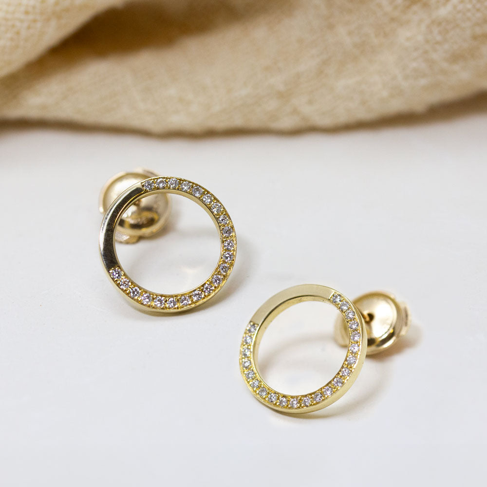 Boucles d'oreille pavées de diamants de synthèse.