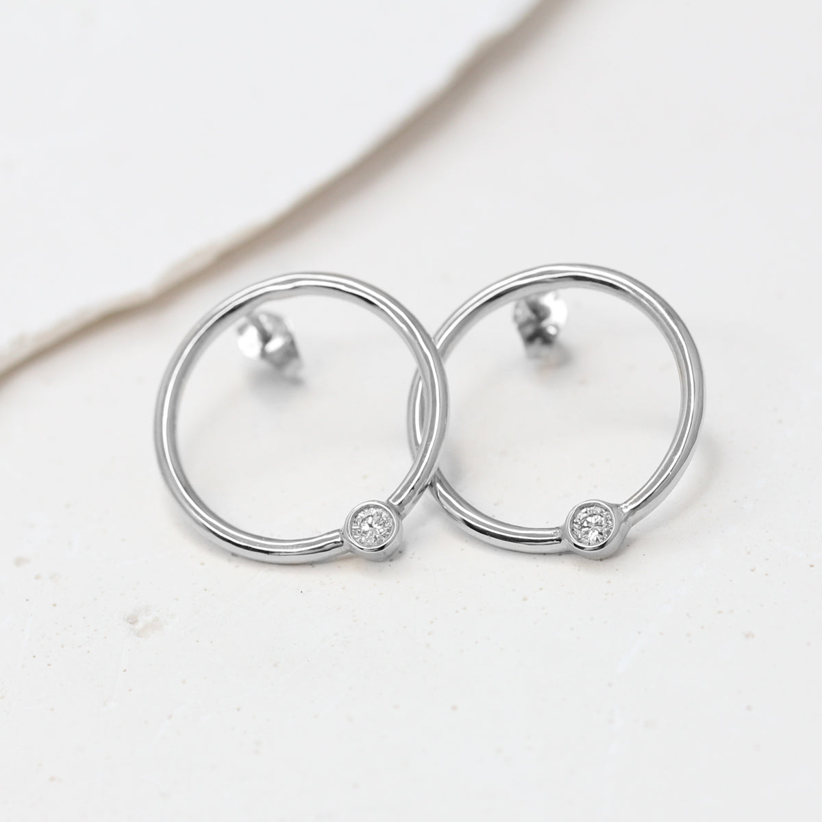 Boucles d’oreilles rondes en or jaune Fairmined 750/1000, qui se déposent délicatement sur le lobe, serties d’un diamant.