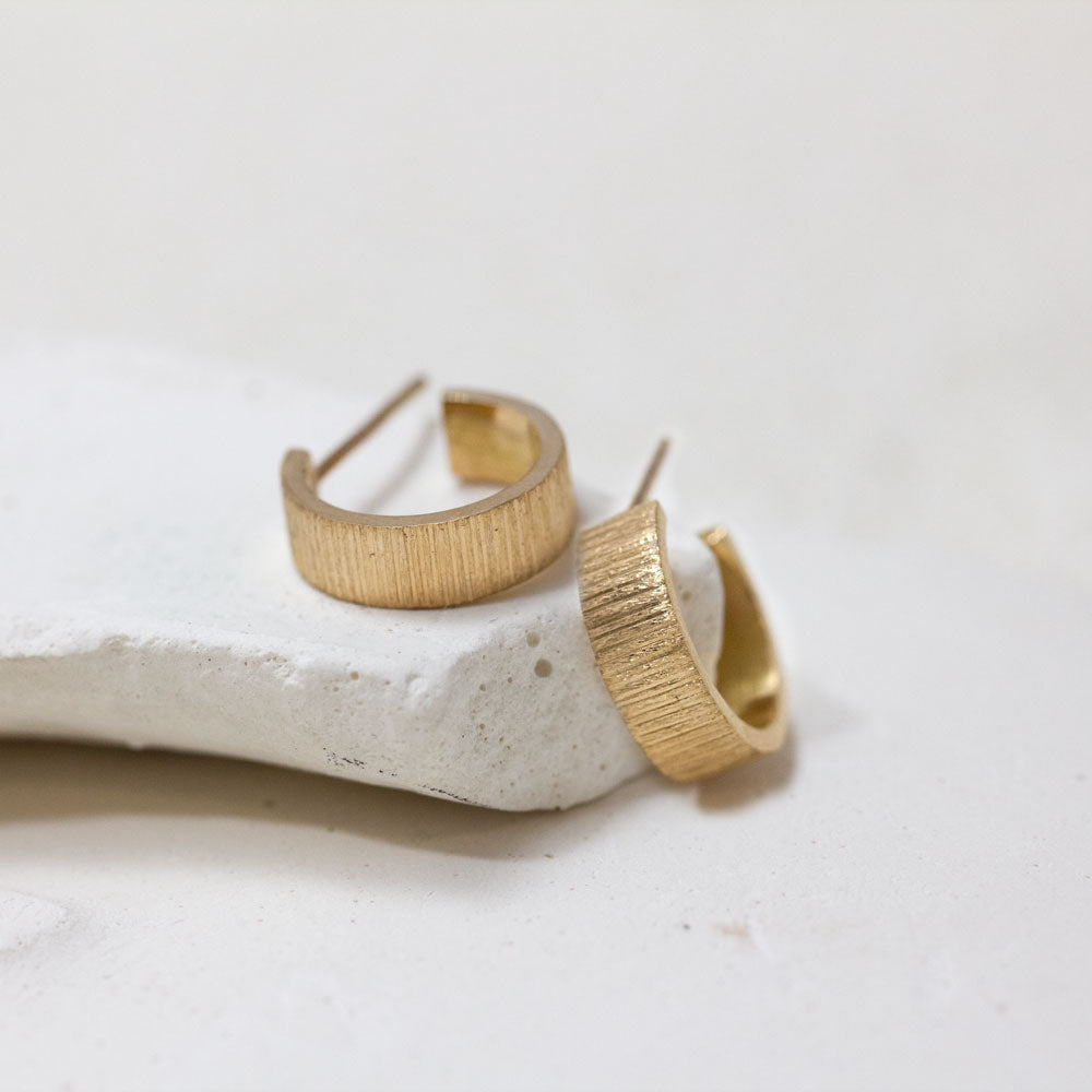 Boucles d'oreille créoles en or texture artisanale, fabriquées à la main dans notre atelier parisien en or recyclé et Fairmined 18 carats.