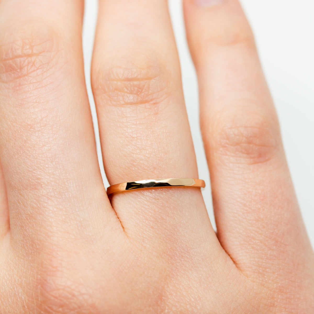 Alliance originale fine femme ruban 1,5 mm Isilde avec facettes martelées, réalisée en or jaune 18 carats recyclé + prime éthique Fairmined à la main dans notre atelier à Paris