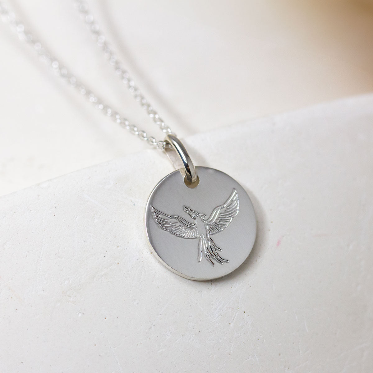 Médaille gravure phoenix en or blanc équitable.