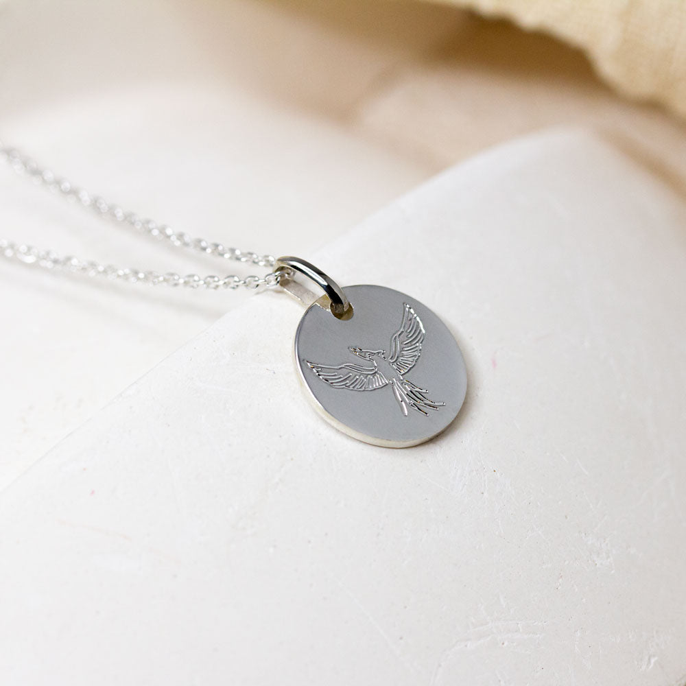 Médaille gravé d'un phoenix en or gris palladié.