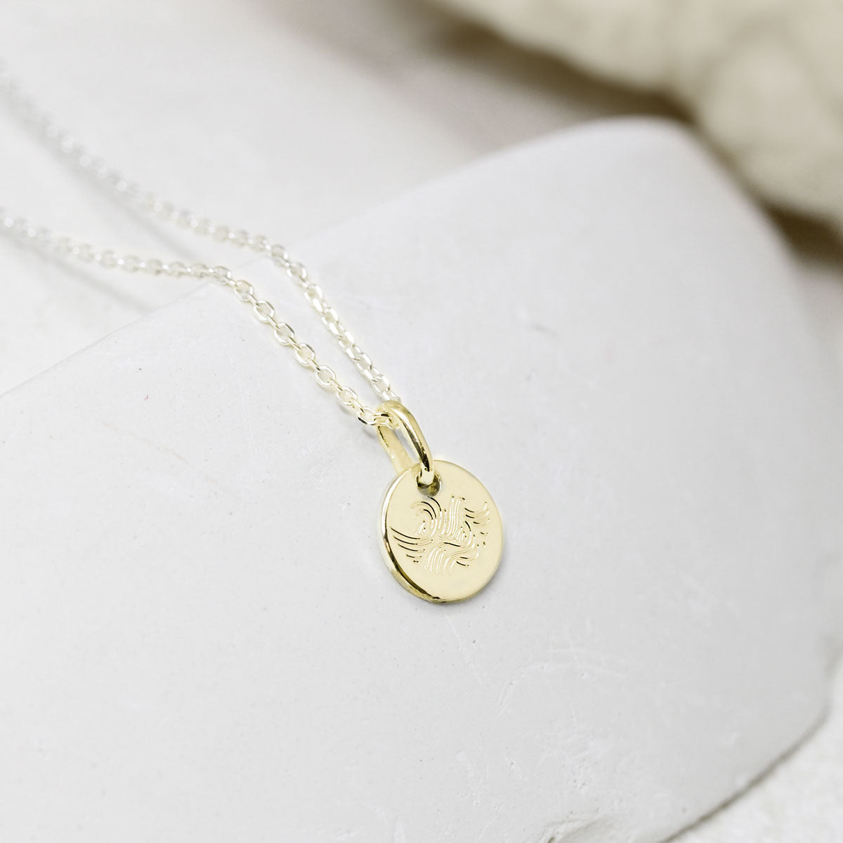 Médaille gravée en or représentant un océan.