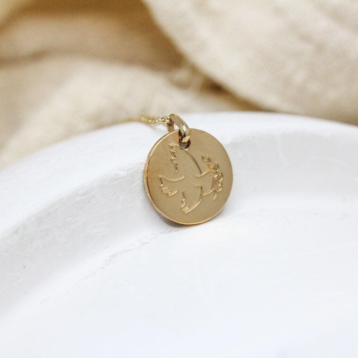 Médaille en or rose-champagne réalisée dans un atelier de joaillerie à Paris.
