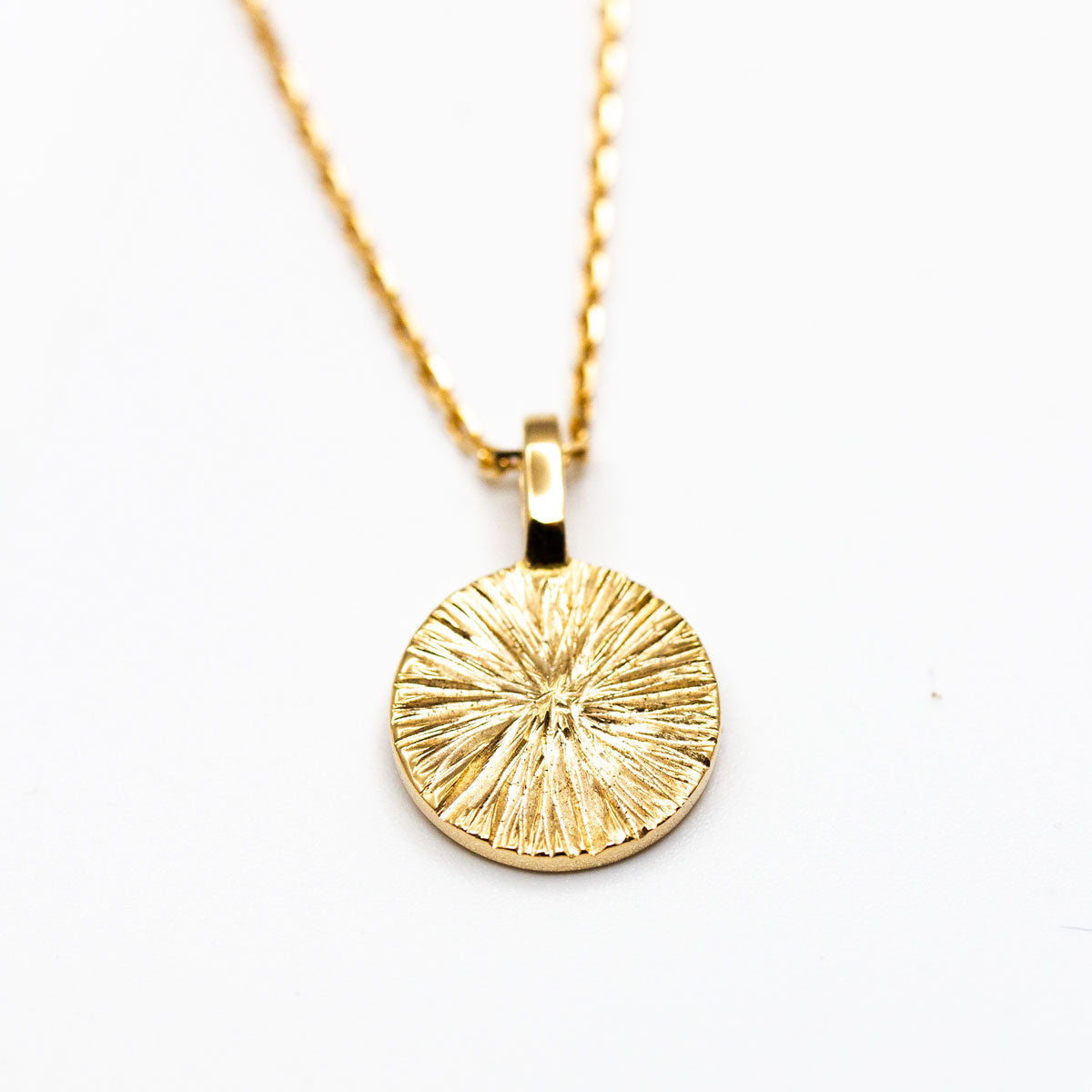 Médaille Arsène ronde 10 mm en or recyclé 18 carats + prime Fairmined réalisée à la main à Paris par nos joailliers, motifs de soleil strié