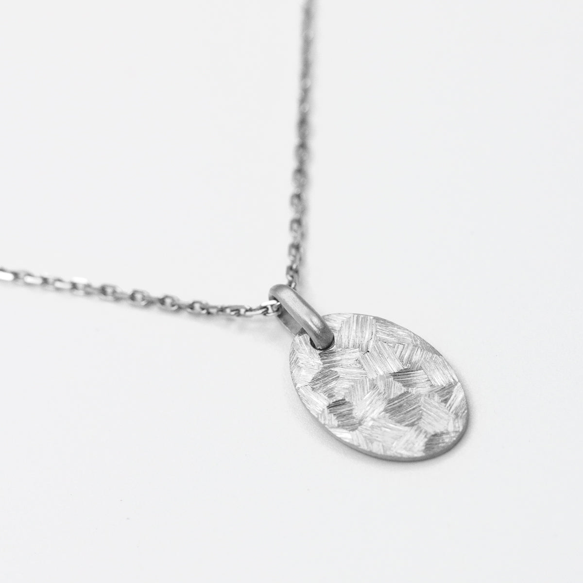 Médaille ovale à graver en or blanc 18 carats recyclé texture martelée et brossée Staël pour femme, joaillerie éthique et fabrication artisanale à Paris