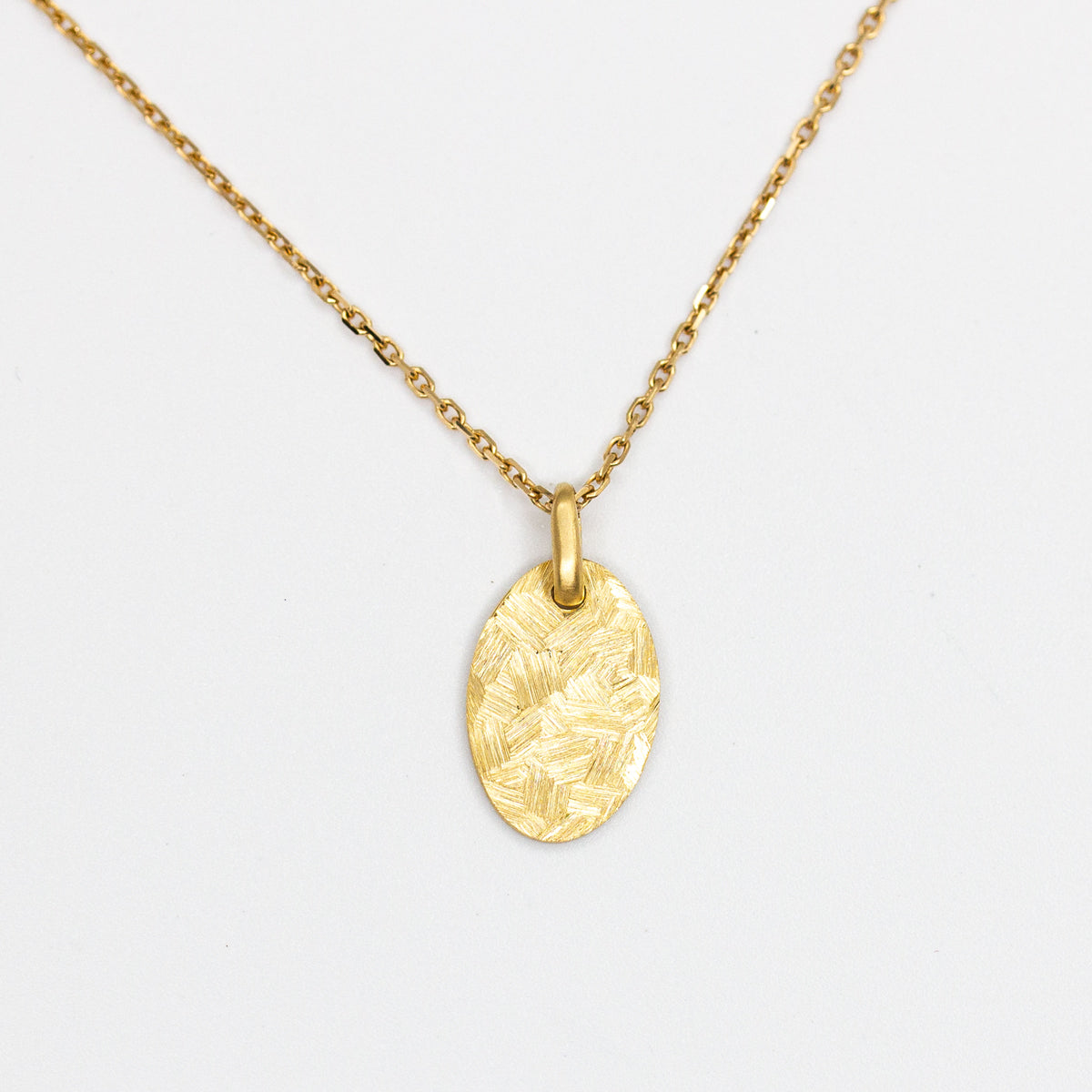 Médaille ovale en or jaune 18 carats recyclé texture martelée et brossée Staël pour femme, joaillerie éthique et fabrication artisanale à Paris