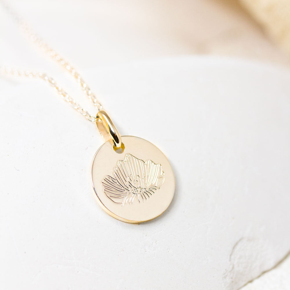 médaille gravée d'un coquelicot dans un atelier de joaillerie à Paris.