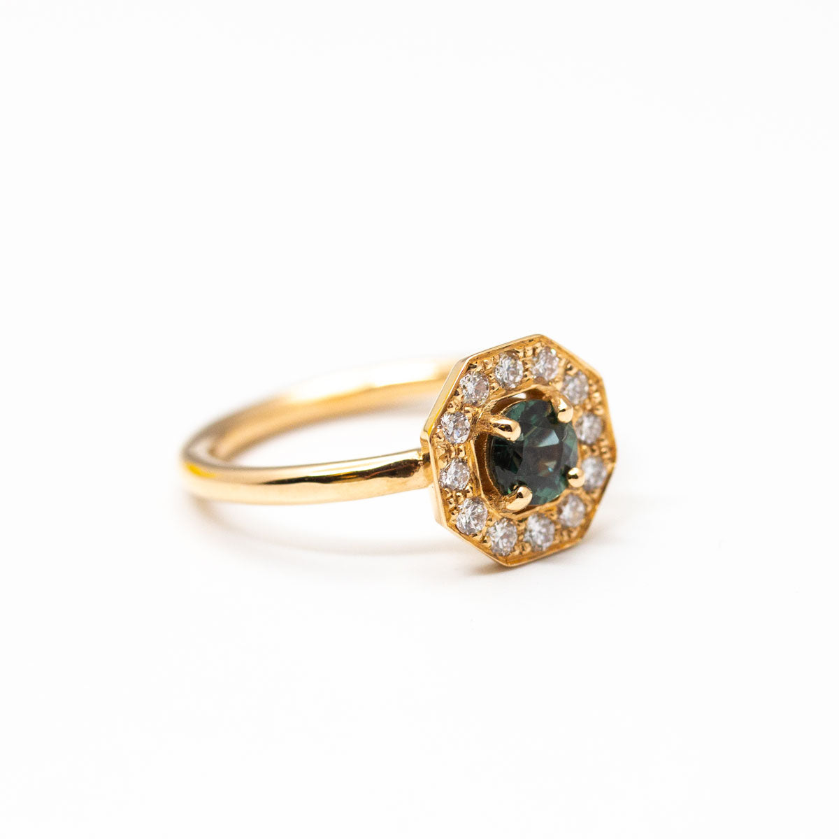 Pièce unique - Bague de fiançailles Art Déco géométrique Leone XL portée, sertie d'un saphir Teal bleu-vert entouré de 16 diamants de synthèse en or rose-champagne recyclé 18 carats. Disponible taille 53, réalisée à Paris dans notre atelier de joaillerie