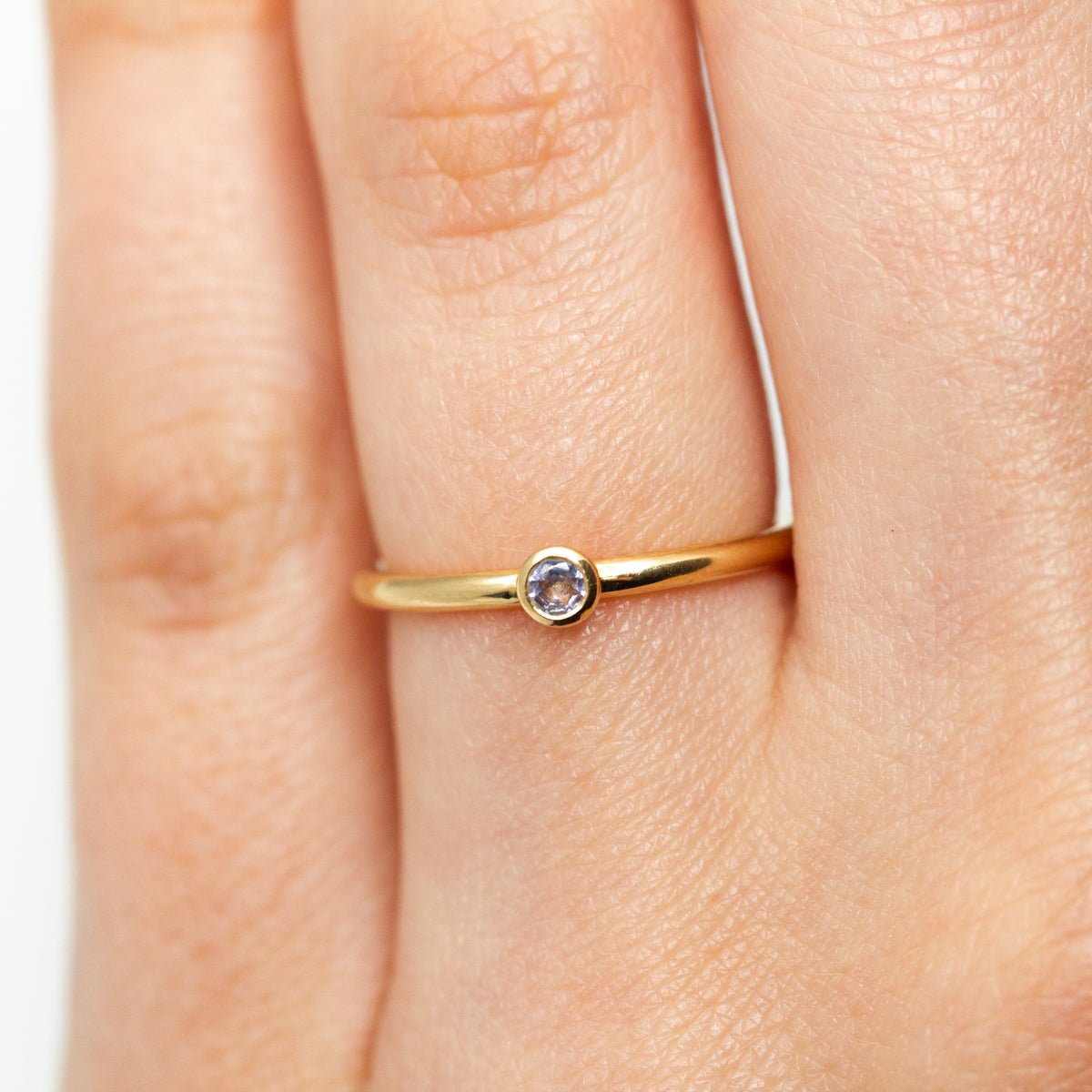 Bague simple petite pierre Pierrette en or rose-champagne 18 carats sertie d'une tanzanite, gemme bleue-violette originale. Joaillerie éthique française made in Paris