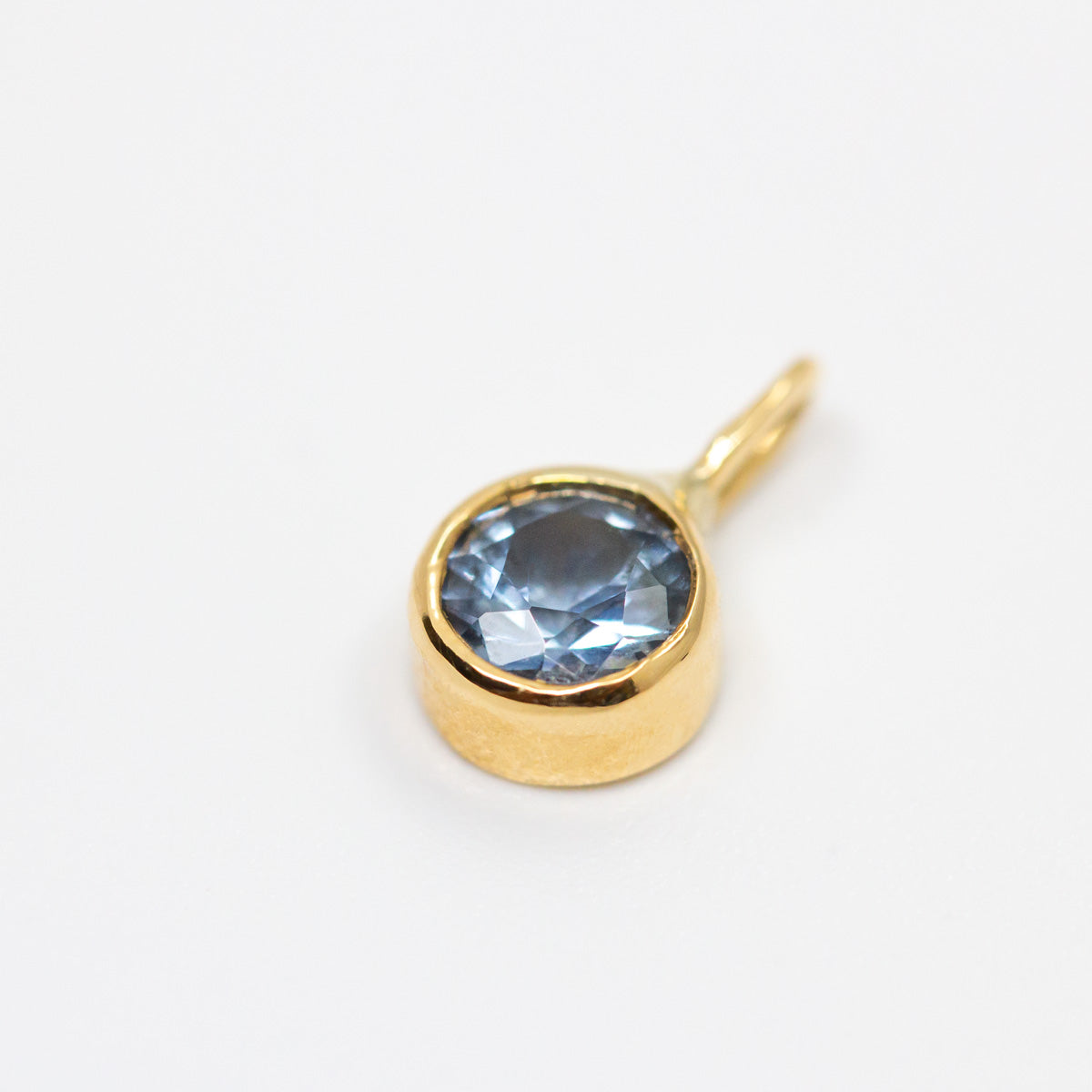 Pendentif Solférine, bijou unique en or jaune Fairmined 18 carats serti d'un saphir bleu pâle, joaillerie éthique fabriquée à la main à Paris