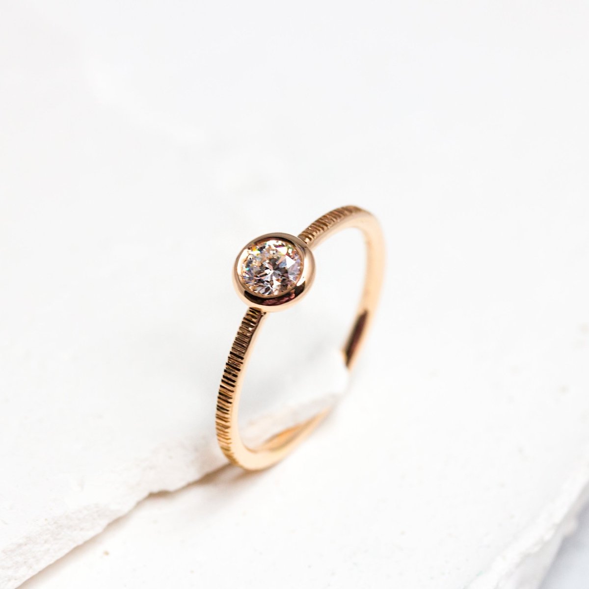 Bague de fiançailles éthique en or rouge avec un diamant de synthèse au centre.