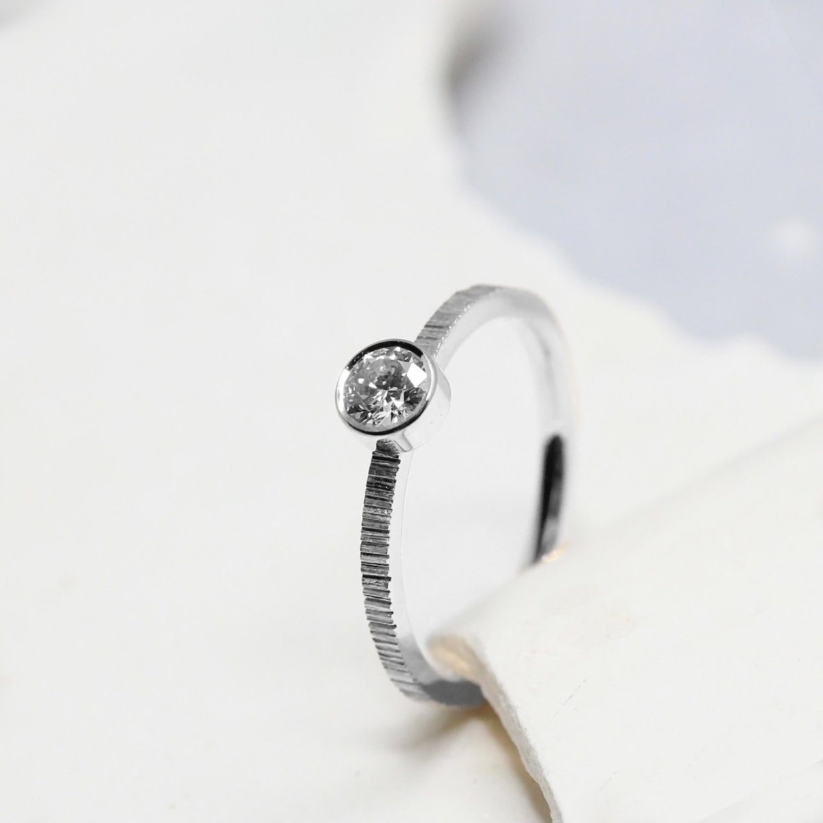 Bague de fiançailles en or blanc ornée d'un diamant.