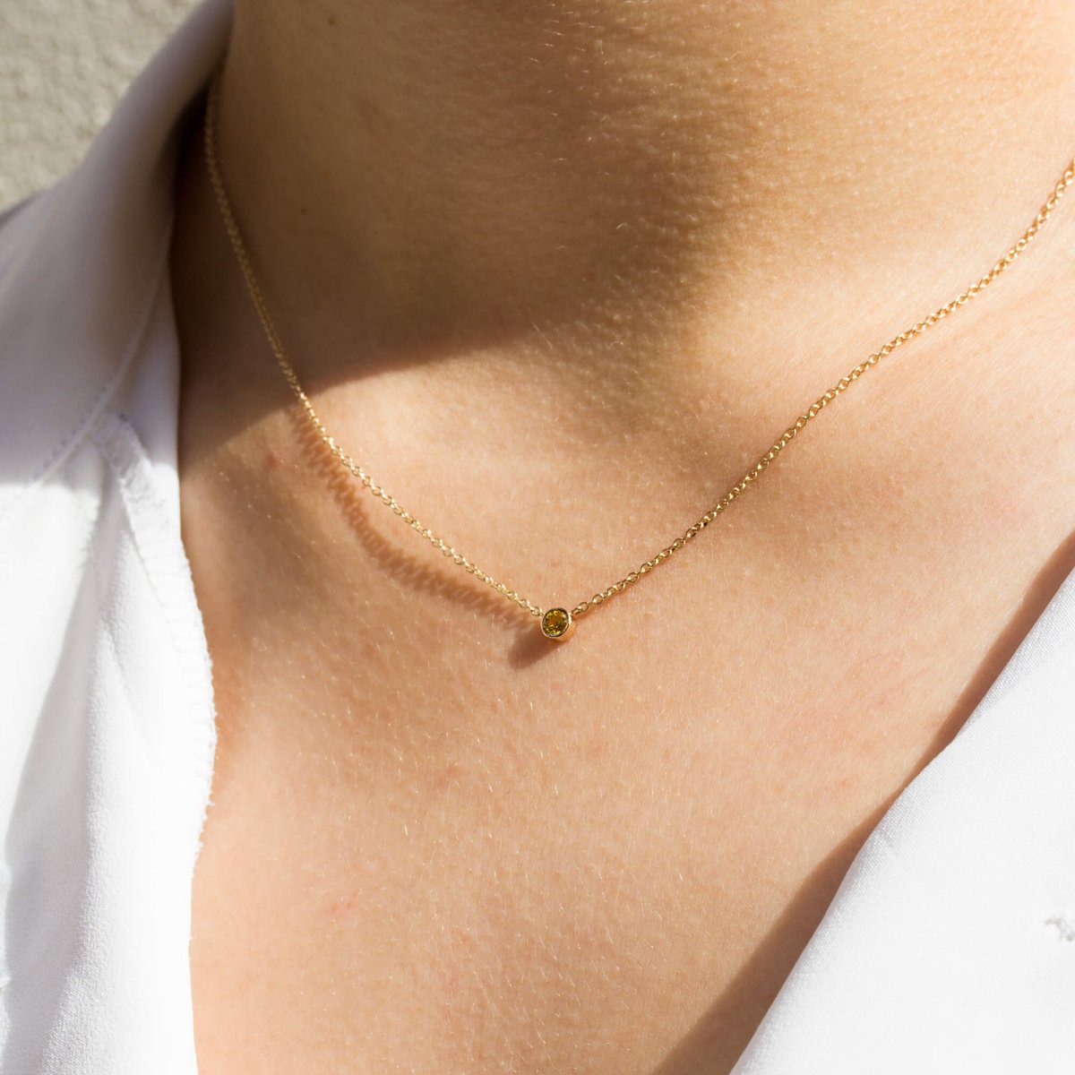 Collier intemporel en or rose orné d'un saphir jaune.