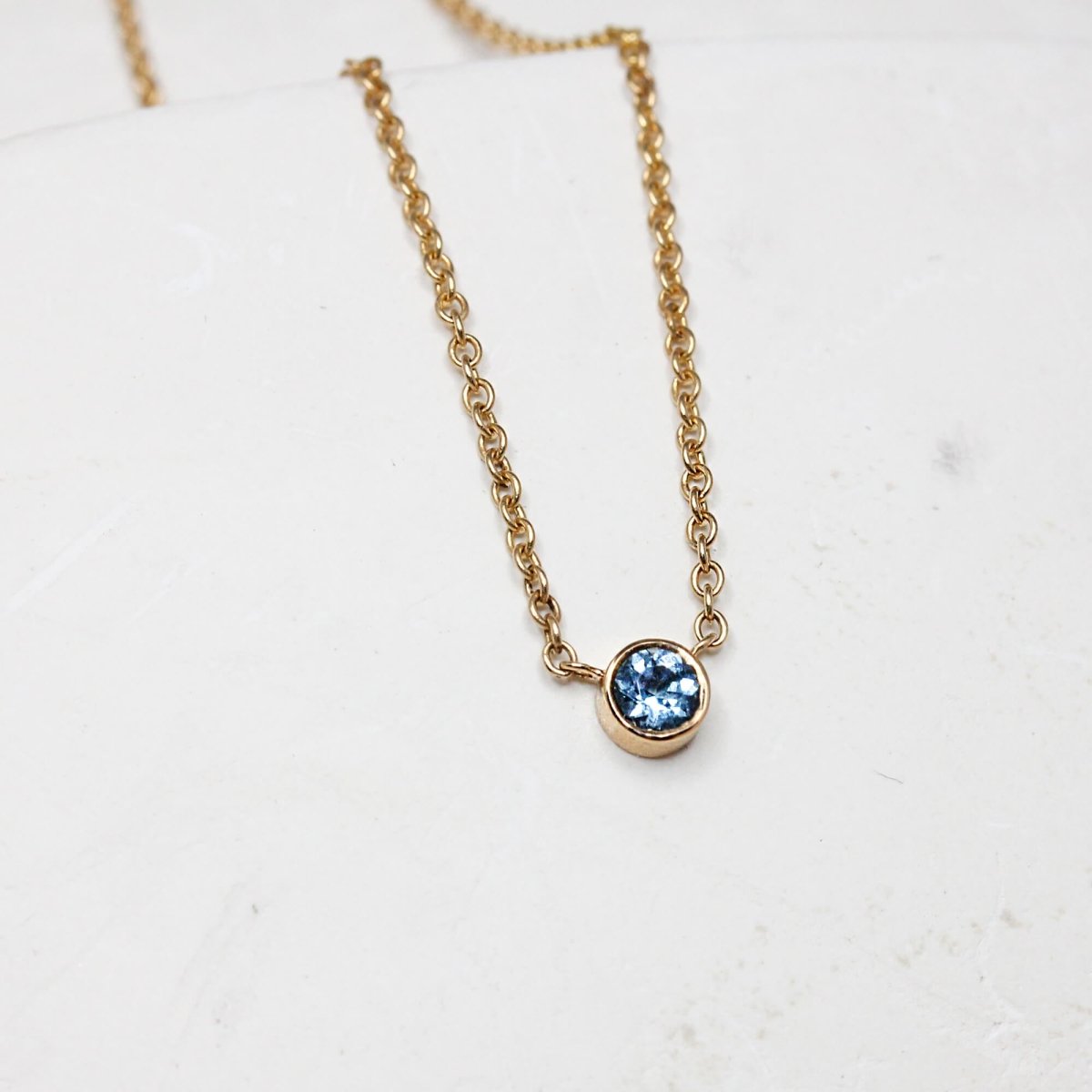 Collier original en or 18 carats Fairmined orné d'une aigue-marine bleue au centre.