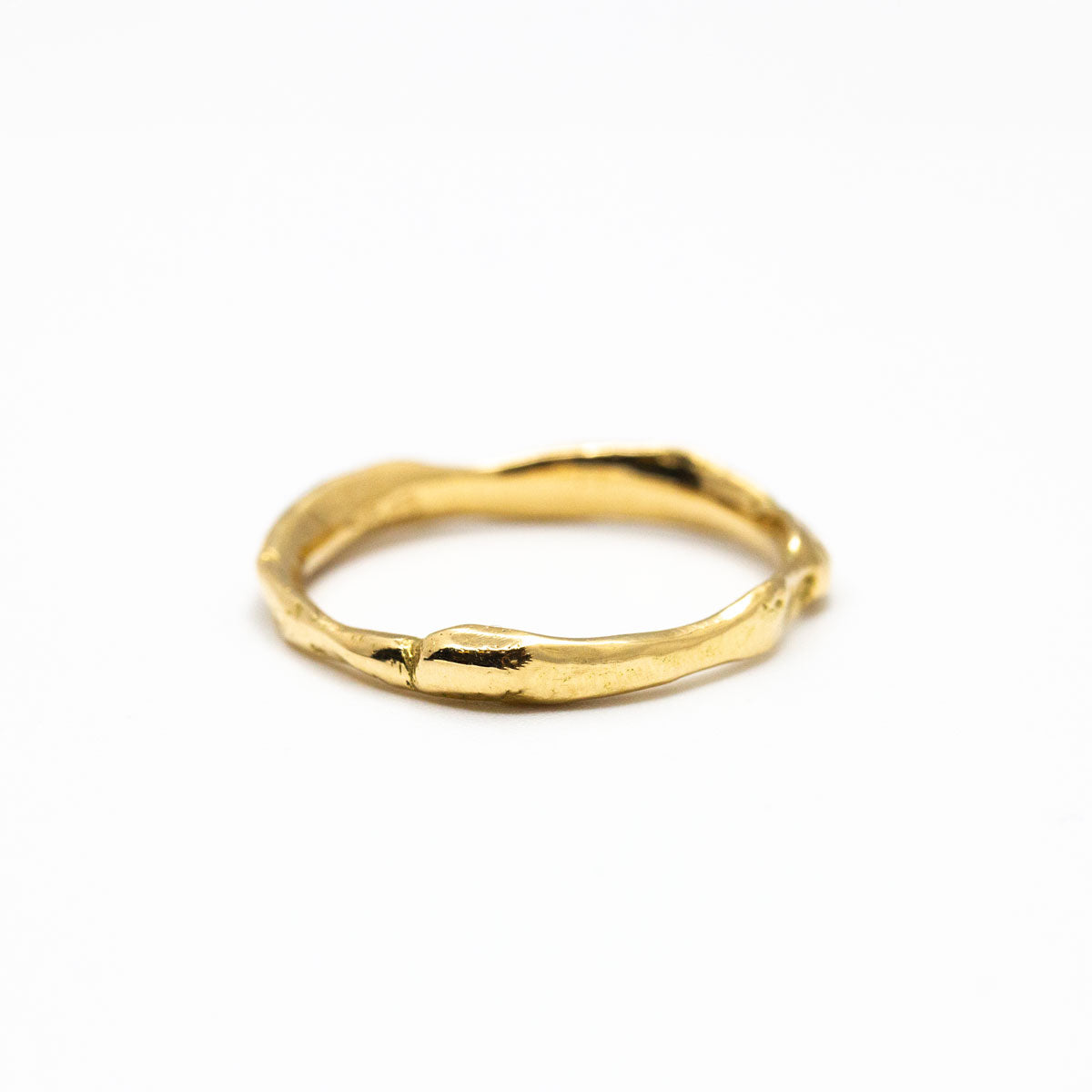 Alliance de mariage ondulée femme en or jaune 750/1000 recyclé + prime Fairmined, avec une texture brute et unique qui rappelle l’or fondu, fabriquée à Paris dans une joaillerie éthique.