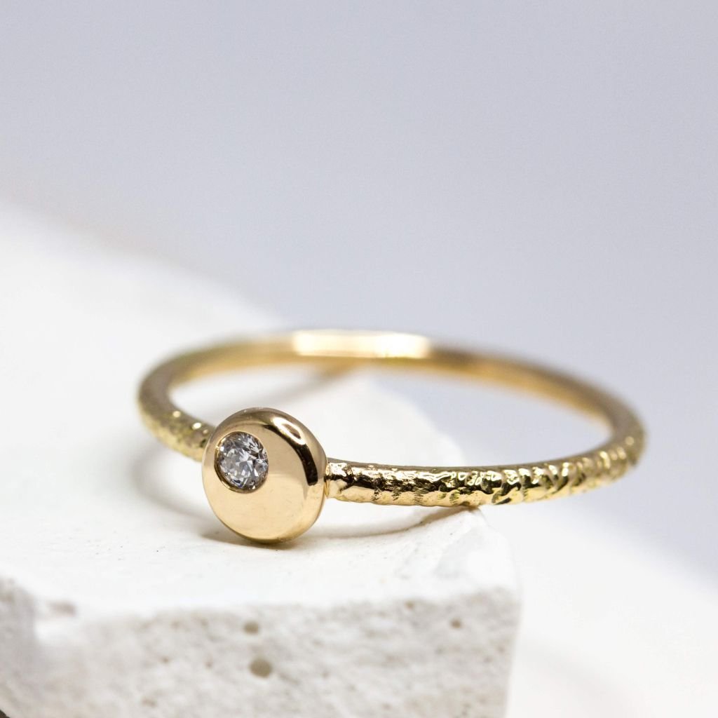 Bague Rosam en or rose-champagne 18 carats ornée d'un diamant de 2 millimètres.