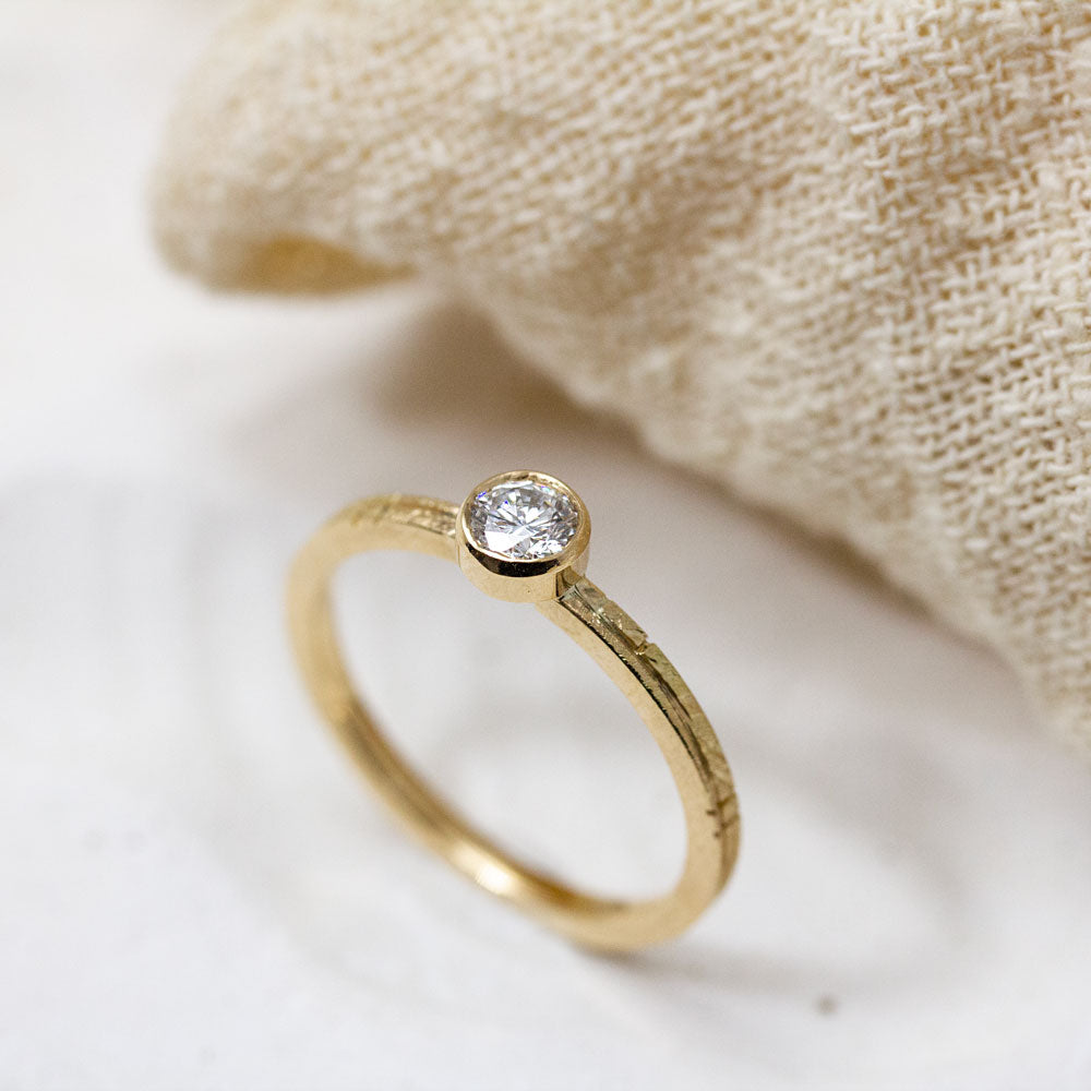 Bague Solférine en or rose-champagne 18 carats Fairmined. L'anneau est texturé à la main et orné d'un serti clos enserrant un joli diamant de synthèse.