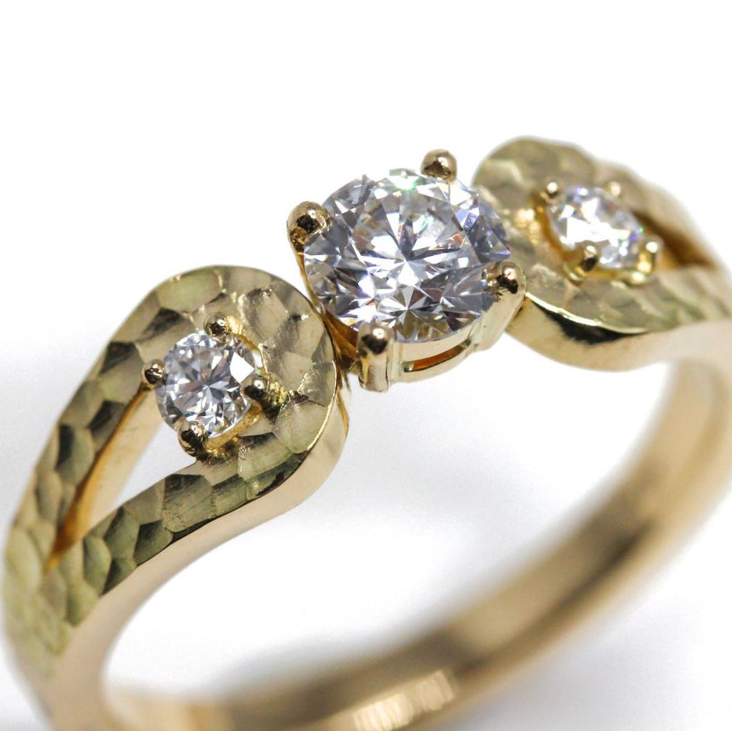 Bague de fiançailles en or jaune ornée de trois diamants.