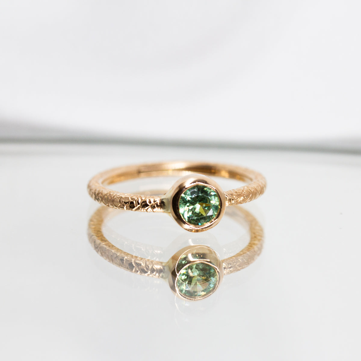 Bague en or rose-champagne 18 carats Fairmined avec en son centre un grenat démantoïde  vert serti clos.