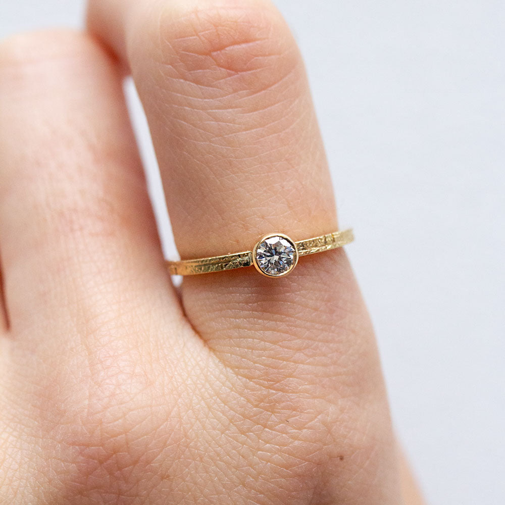 Bague Solférine en or rose-champagne. L'anneau en or  18 carats est texturé et orné d'un diamant de synthèse.
