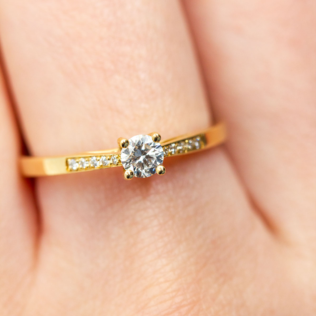 Bague solitaire pavée sertie d'un diamant central de 4mm et de 10 diamants de synthèse en or jaune recyclé 750/1000 et prime Fairmined. Fabriquée avec savoir-faire à la main dans notre atelier de joaillerie à Paris