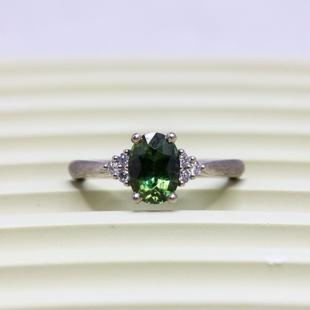 Bague avec saphir vert et diamants de synthèse.