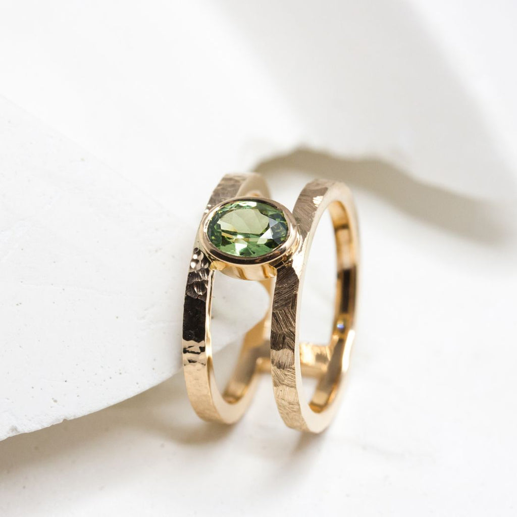 Bague double anneau en or Fairmined ornée d'un saphir vert ovale.