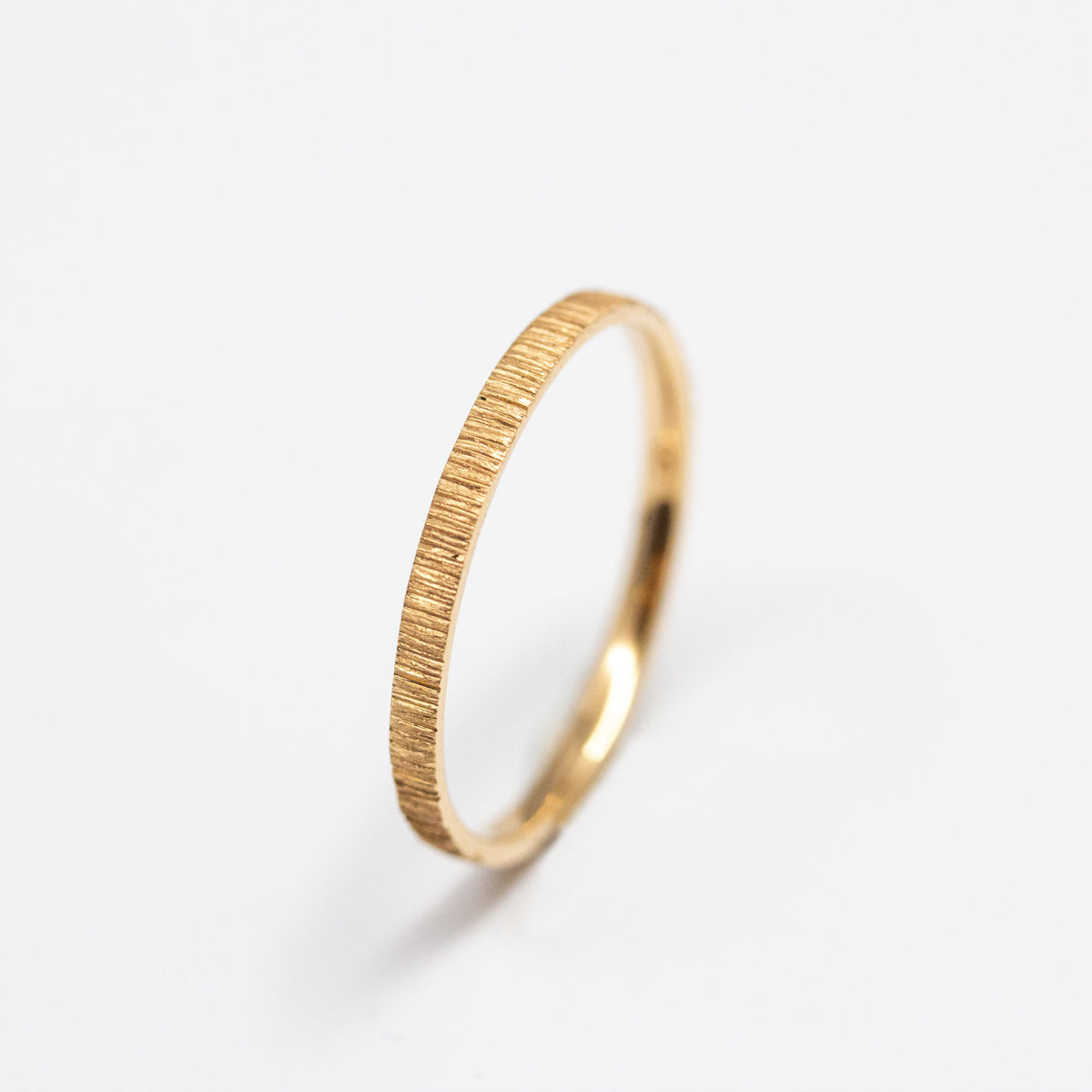 Alliance striée femme texture artisanale Isandre en or rose-champagne recyclé 18 carats + prime Fairmined. Joaillerie éthique et fabrication artisanale