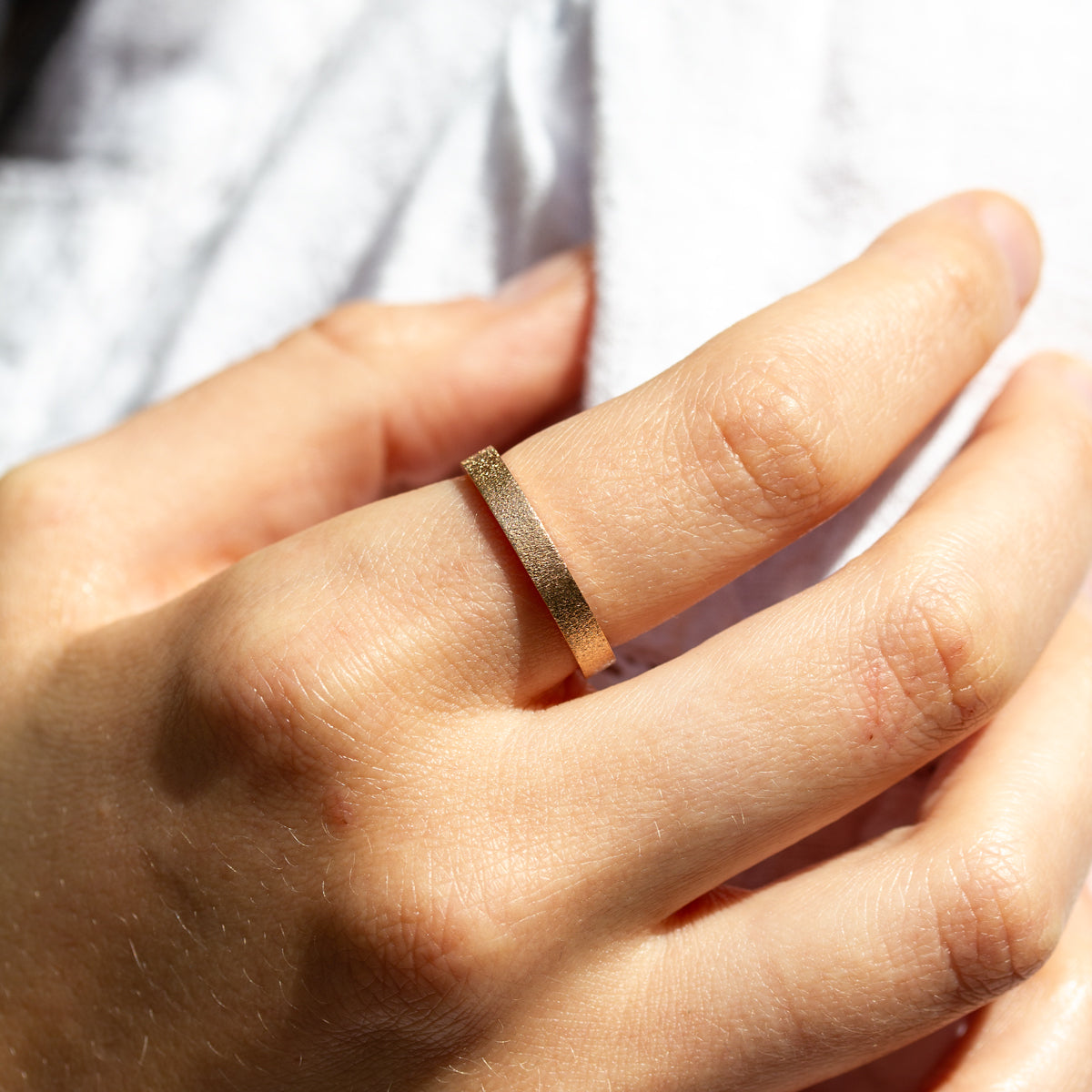 Alliance texturée ruban 3mm en or jaune Fairmined 750/1000, façonnée dans une joaillerie éthique. 
