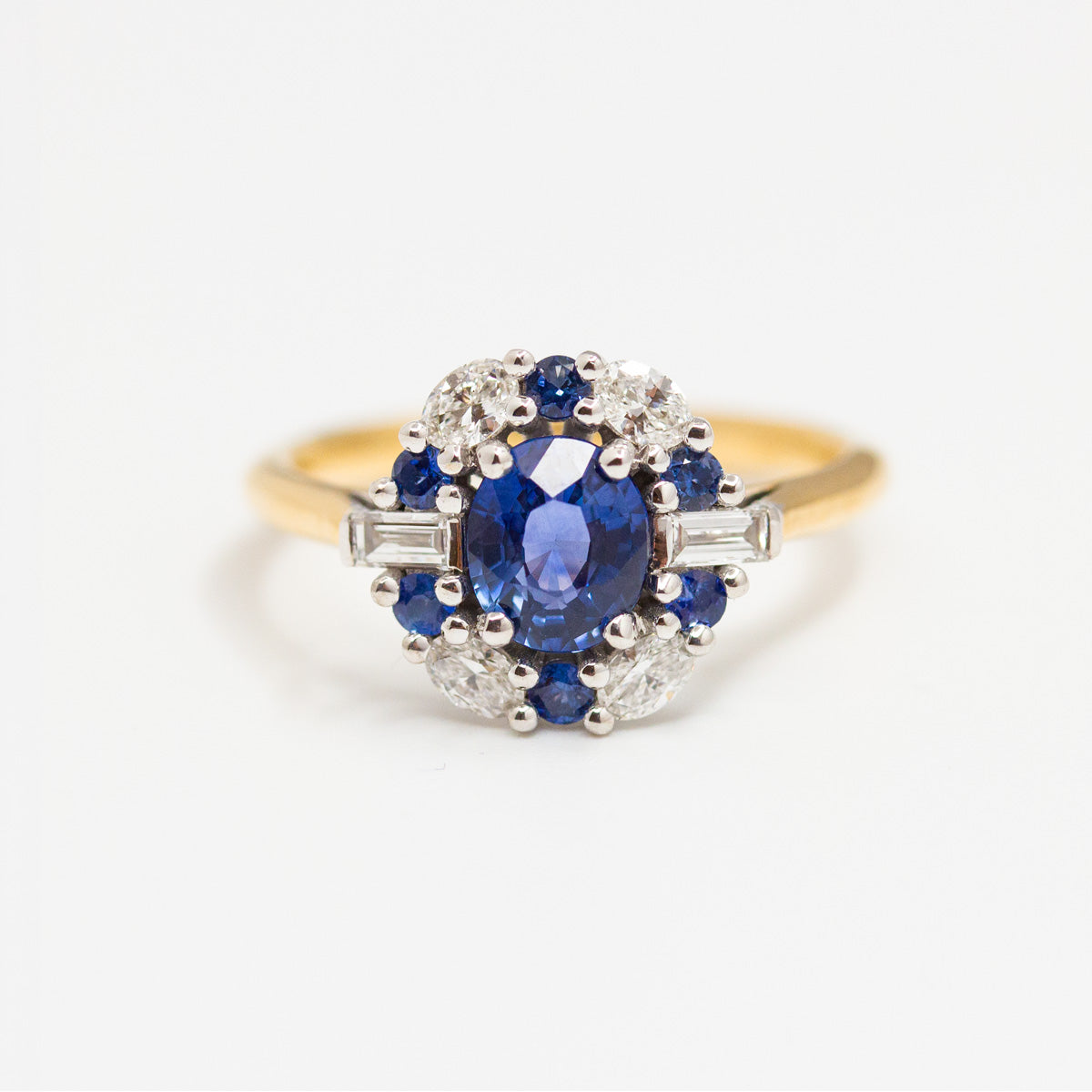 Bague entourage saphir bleu de Ceylan, épaulé de diamants de synthèse taille baguette, pavage de saphirs et diamants. Fabriquée en or 750/1000 Fairmined dans notre atelier de joaillerie indépendant 