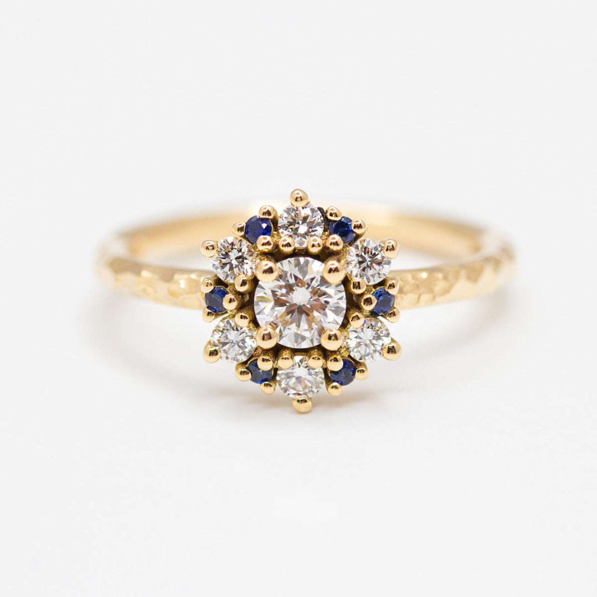 Bague entourage créée sur-mesure ornée de diamants et de saphirs bleus, fabriquée en or jaune 750/1000 recyclé avec prime Fairmined
Bijou sur mesure de joaillerie éthique