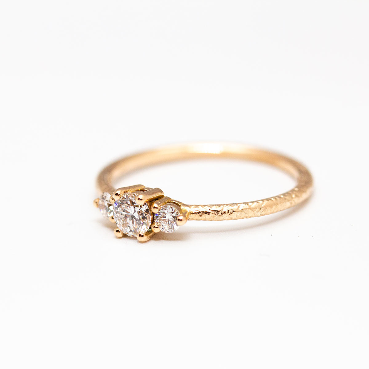 Bague de fiançailles épaulée femme Soleine jonc 1,5 et 3 diamants de synthèse réalisée à la main en or rouge recyclé 18 carats et crédit Fairmined